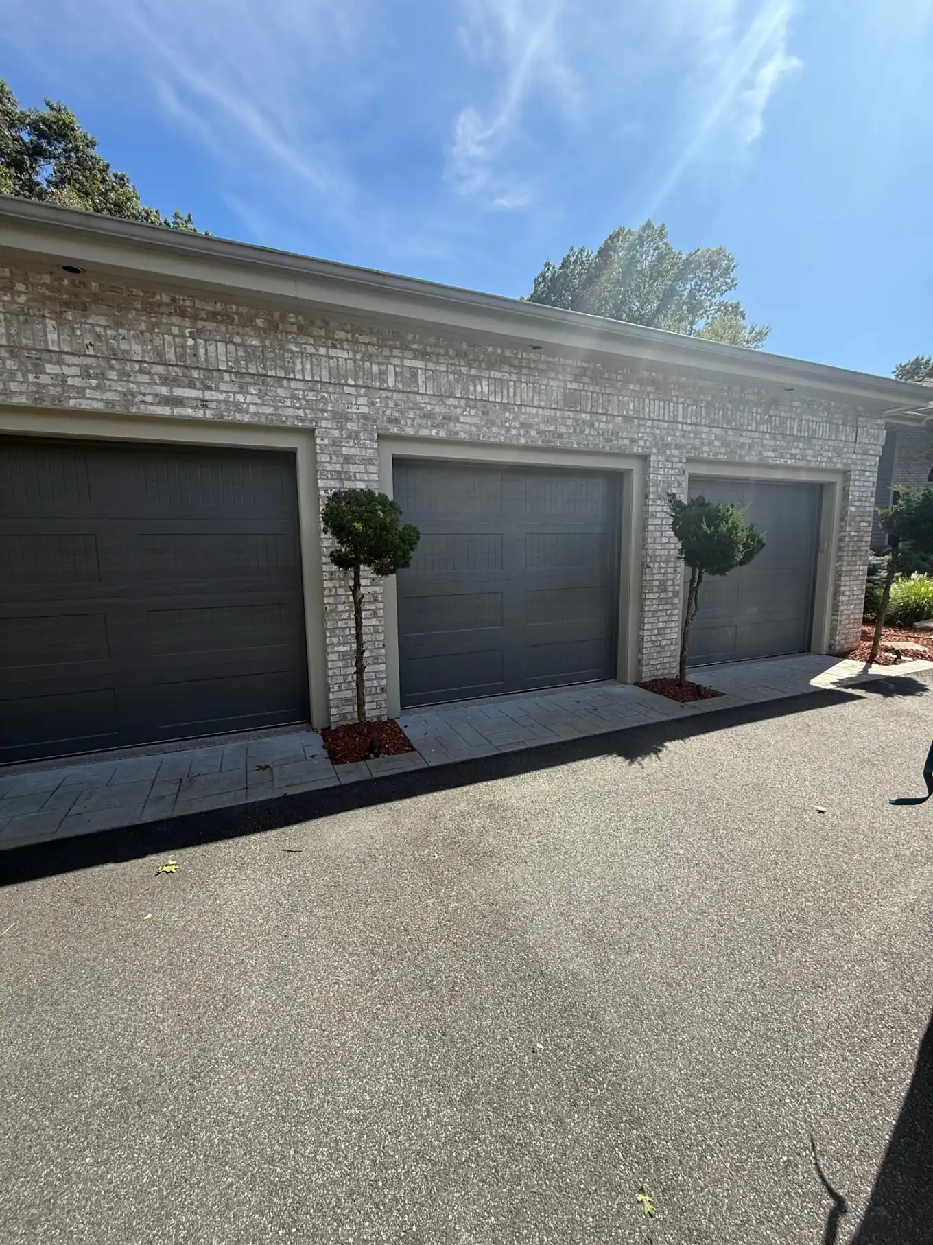 Three dark residential garage doors shown after installation